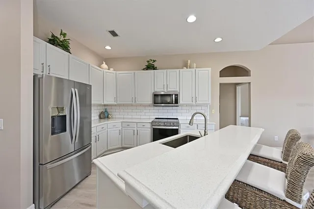 a kitchen with granite countertop a refrigerator stove and microwave