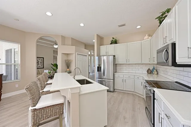 a kitchen with stainless steel appliances a stove a sink a refrigerator and cabinets