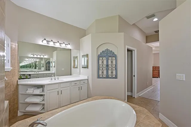 a large bathroom with a sink a large mirror and a bathtub