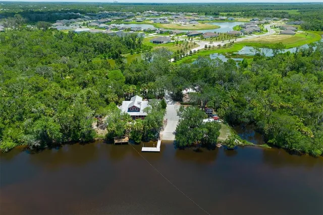 an aerial view of residential houses with outdoor space and lake view