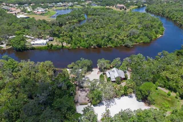 an aerial view of a house with a yard and lake view