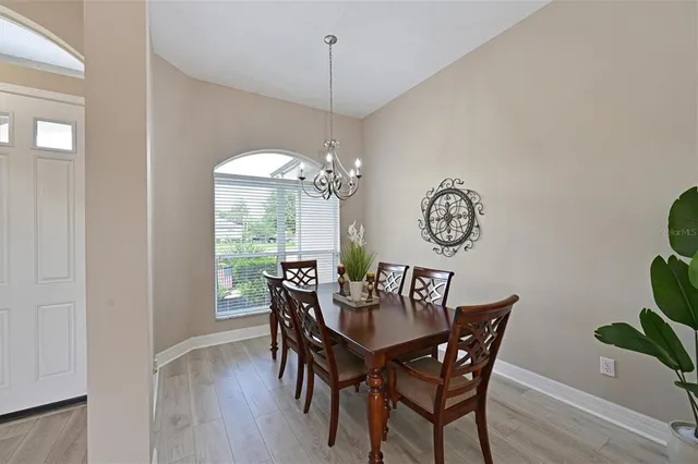 a view of a dining room with furniture a chandelier and wooden floor