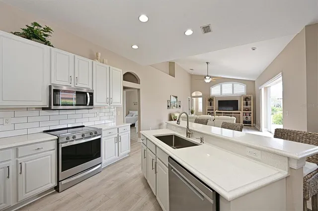a kitchen with stainless steel appliances granite countertop a sink stove oven and refrigerator