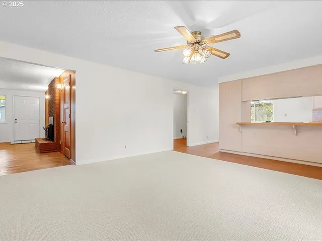 a view of a livingroom with a ceiling fan and window