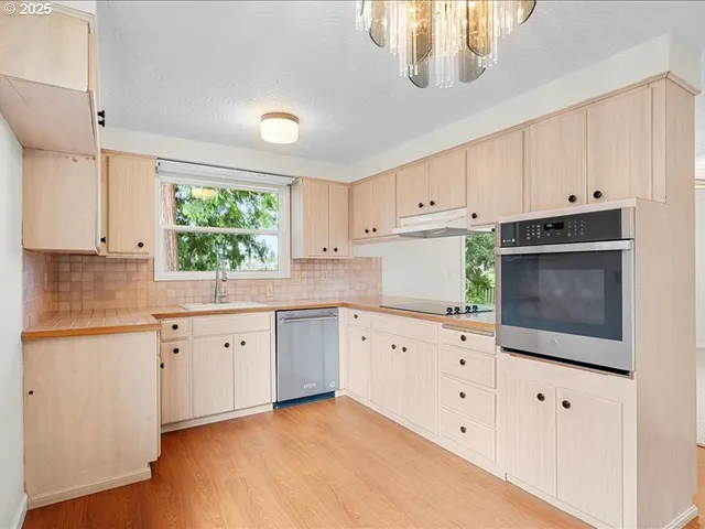a kitchen with granite countertop white cabinets white stainless steel appliances with a sink and dishwasher