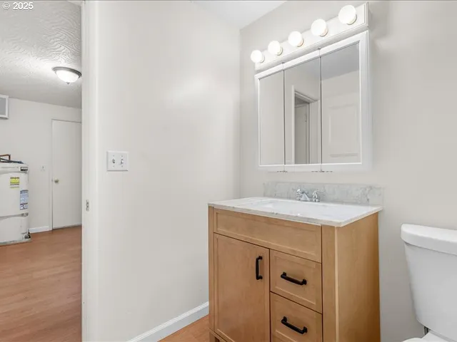 a bathroom with a sink a toilet and a mirror