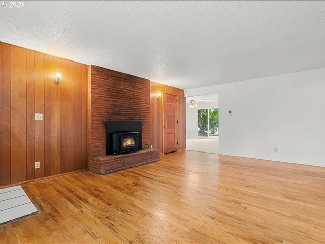 a view of an empty room with a window and a fireplace