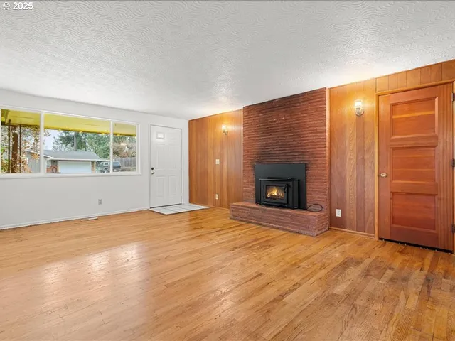 an empty room with windows and fireplace