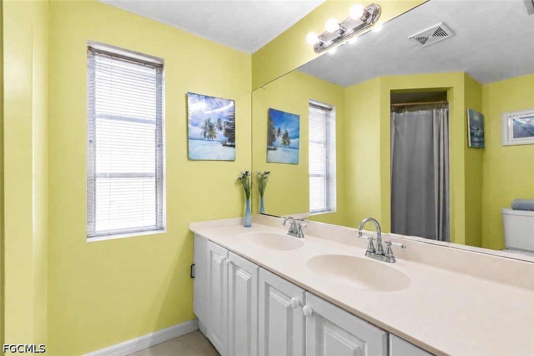18 Illinois Road Lehigh Acres, FL 33936 - Photo 39 of 45 a bathroom with a double vanity sink and a mirror
