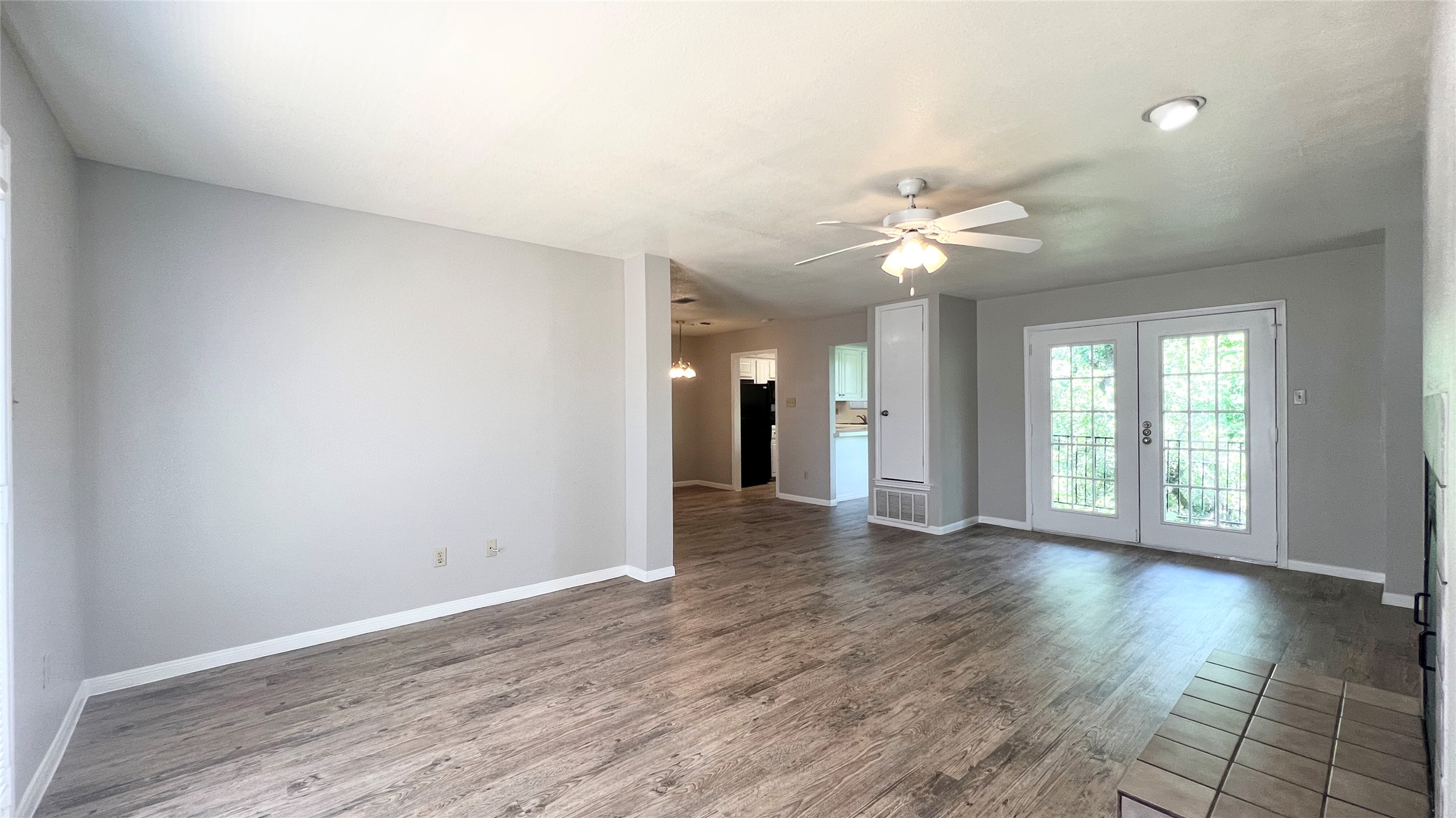 9201 Simmons Road, Unit 117 Austin, TX 78759 - Photo 4 of 20 Natural light streams into this generously sized common room with wood-look flooring and a ceiling fan.