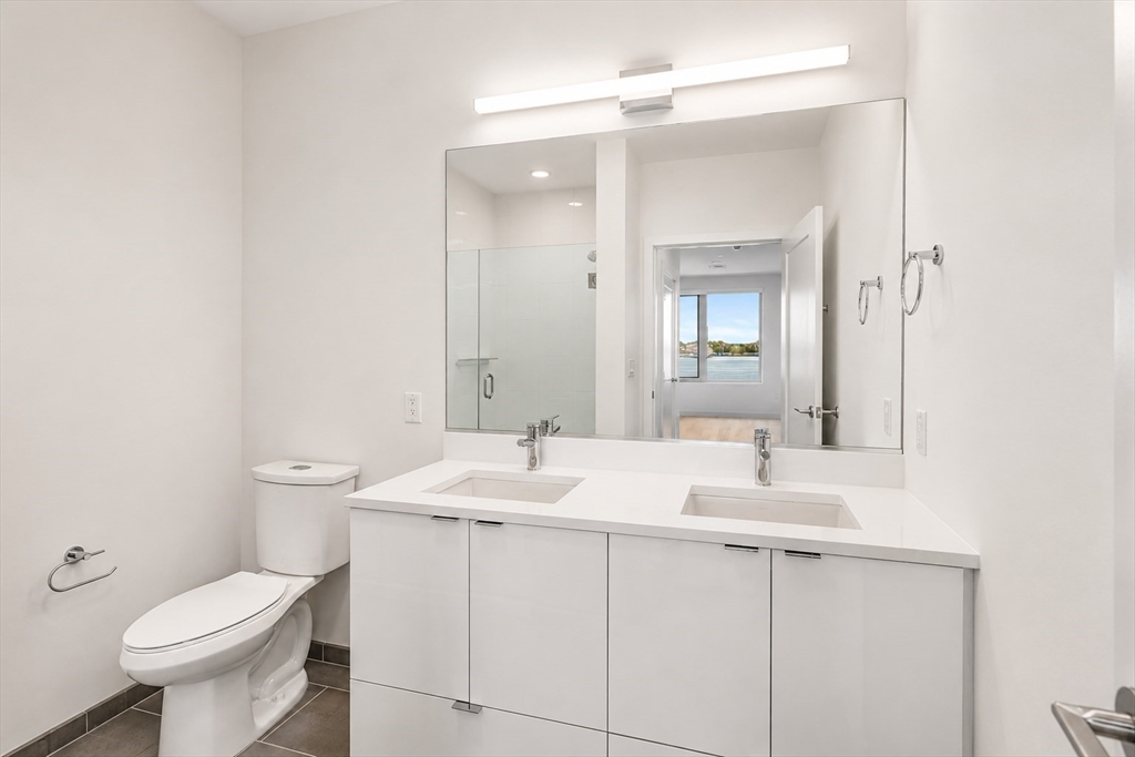 45 Lewis Street, Unit 312 Boston, MA 02128 - Photo 8 of 17 a bathroom with a toilet sink and mirror