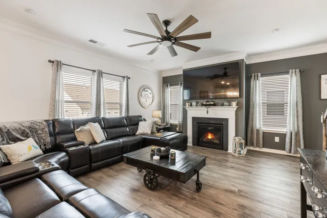 a kitchen with stainless steel appliances granite countertop a refrigerator a stove a sink a dining table and chairs with wooden floor