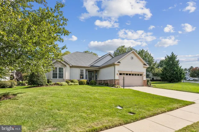 a view of house with a big yard and potted plants