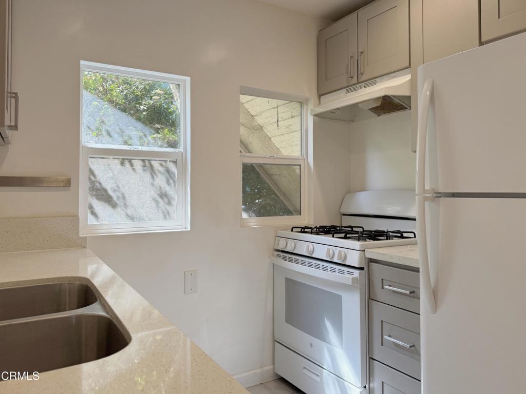 a kitchen with white cabinets and a stove