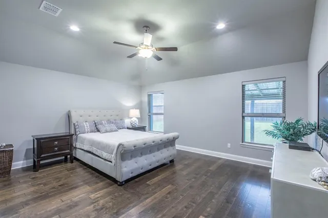 a bedroom with a large bed chandelier and a window
