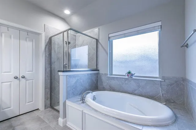 a bathroom with a white bath tub and a shower