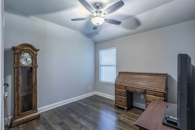 a room with a clock on wall and a ceiling fan