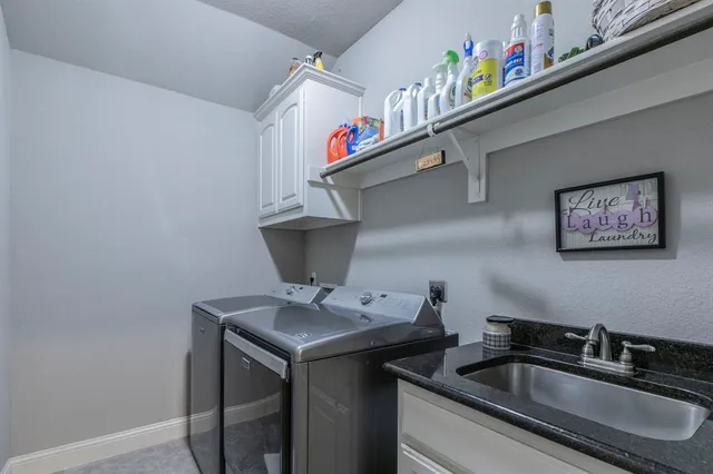 a utility room with dryer and sink