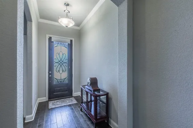 a hallway with wooden floor chandelier and entryway