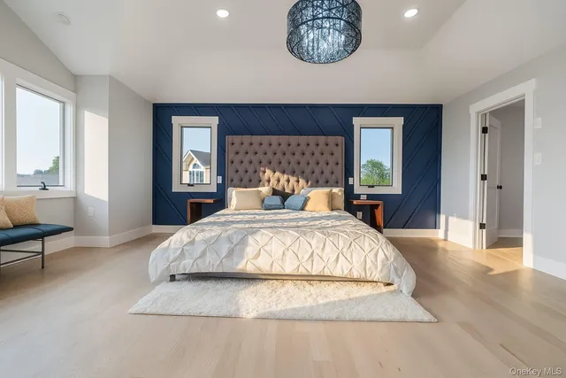 a spacious bedroom with a bed and wooden floor