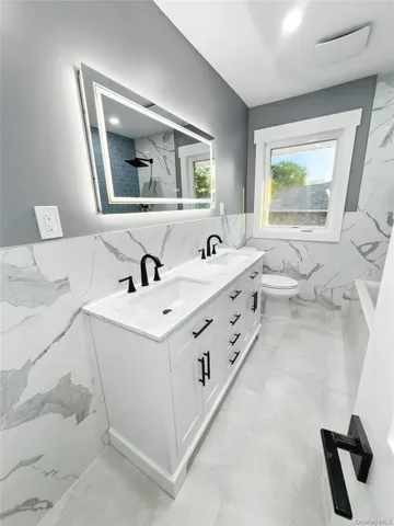 a bathroom with a double vanity sink a mirror and a bathtub