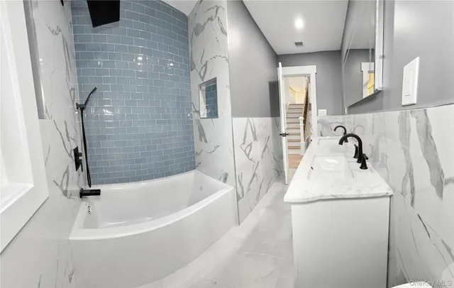 a bathroom with a sink a bathtub and shower