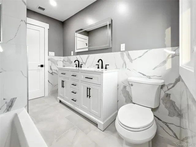 a white toilet sitting next to a bathroom sink