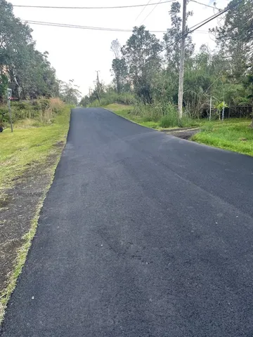 a view of a field with a trees in the background