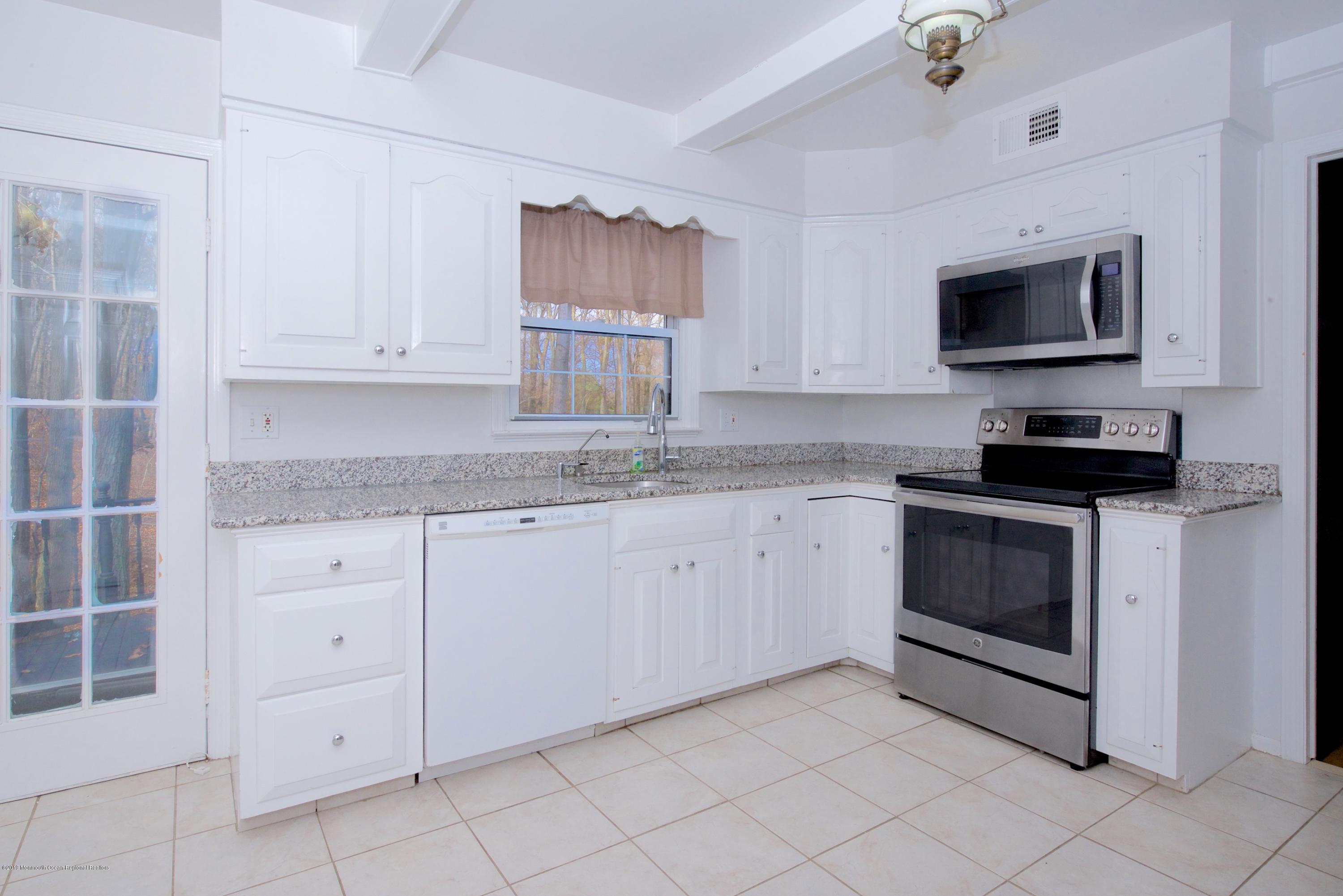 131 Millstone Road Millstone Township, NJ 08535 - Photo 11 of 27 a kitchen with white cabinets and a stove