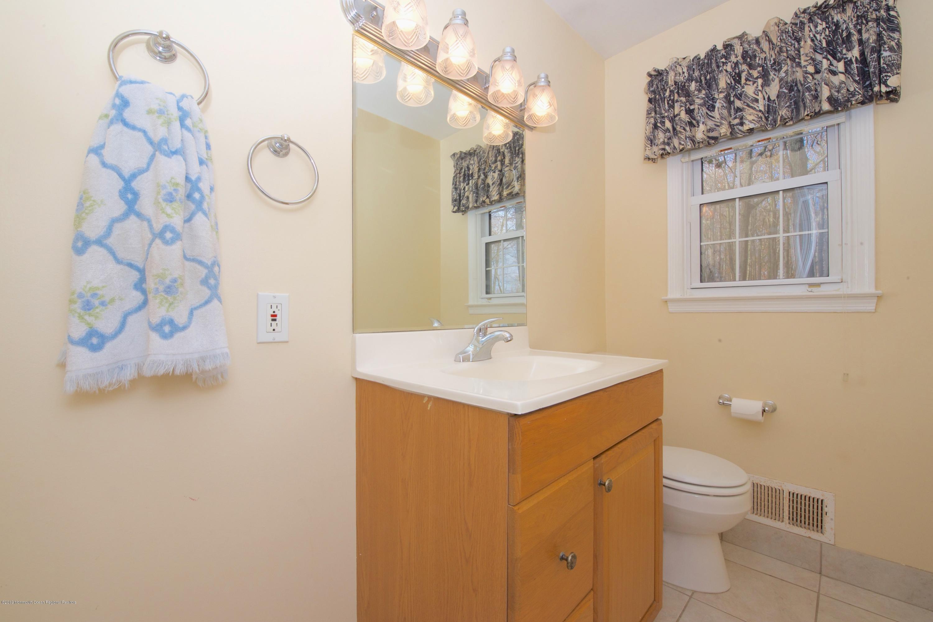 131 Millstone Road Millstone Township, NJ 08535 - Photo 12 of 27 a bathroom with a sink a toilet and a mirror