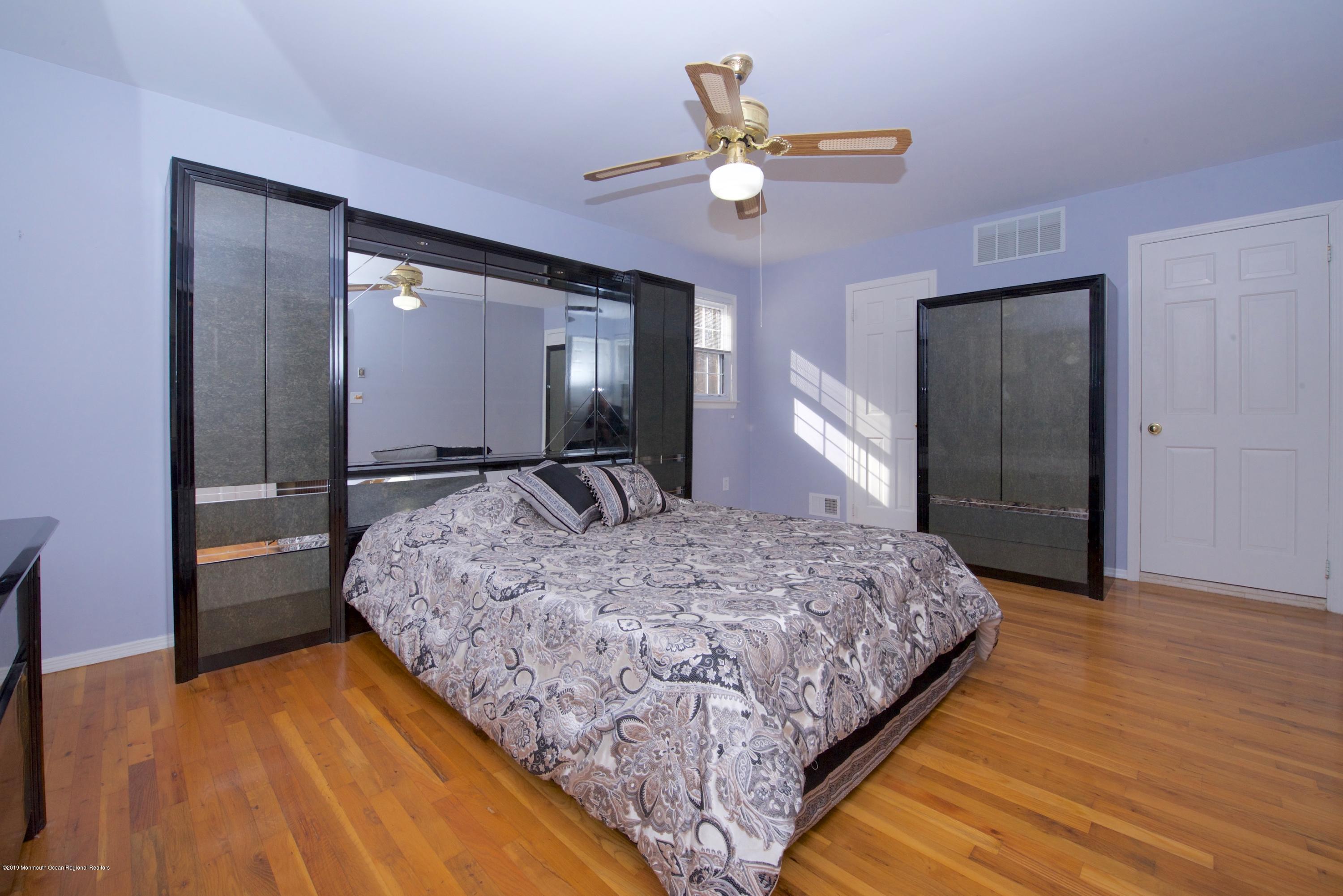 131 Millstone Road Millstone Township, NJ 08535 - Photo 16 of 27 a bedroom with a bed and a chandelier