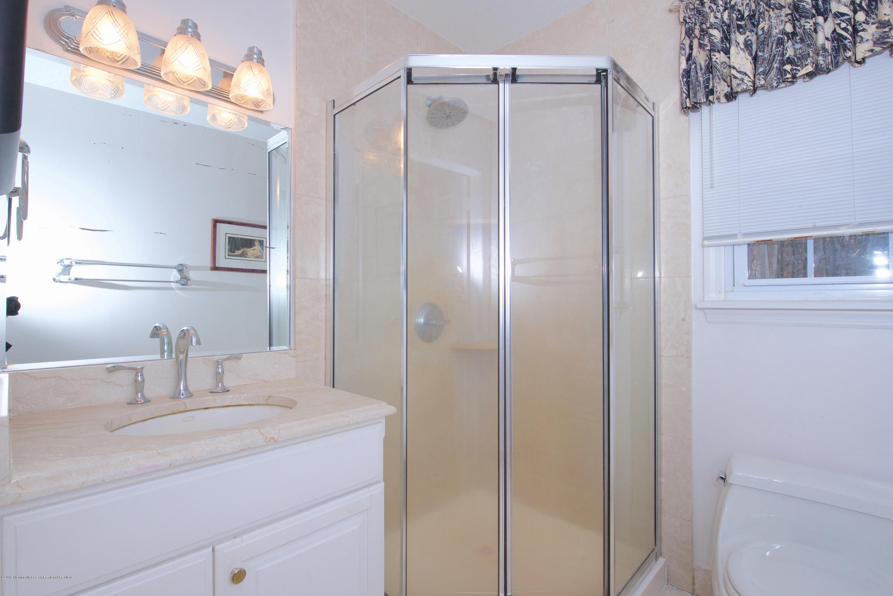 131 Millstone Road Millstone Township, NJ 08535 - Photo 19 of 27 a bathroom with a granite countertop sink a mirror and a shower