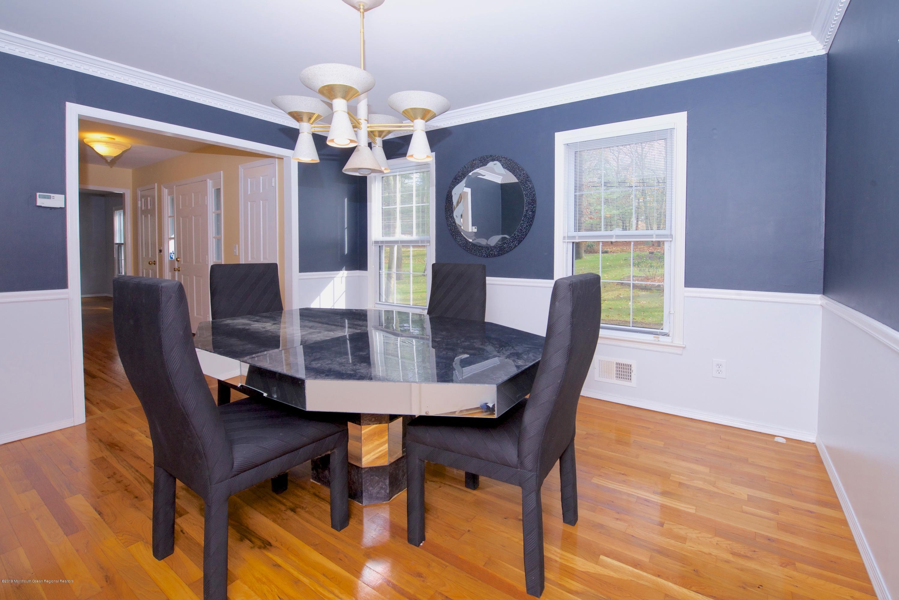 131 Millstone Road Millstone Township, NJ 08535 - Photo 7 of 27 a dining room with furniture a chandelier and wooden floor