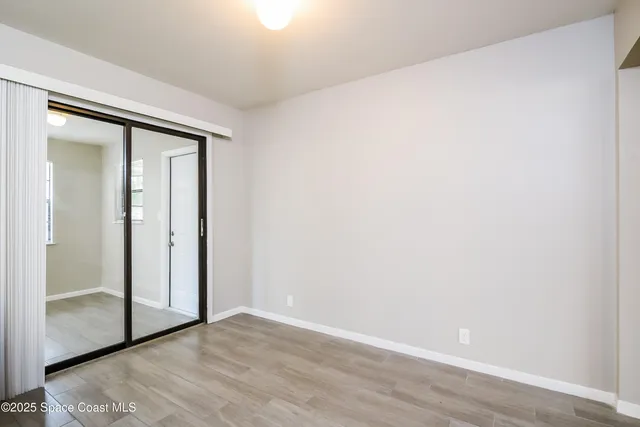 an empty room with wooden floor and sliding door