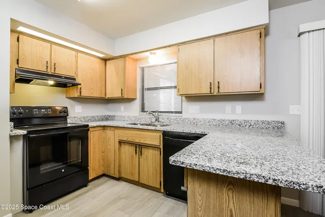 a kitchen with stainless steel appliances granite countertop a stove sink and cabinets