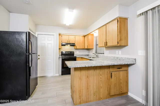 a kitchen with a refrigerator a sink and cabinets