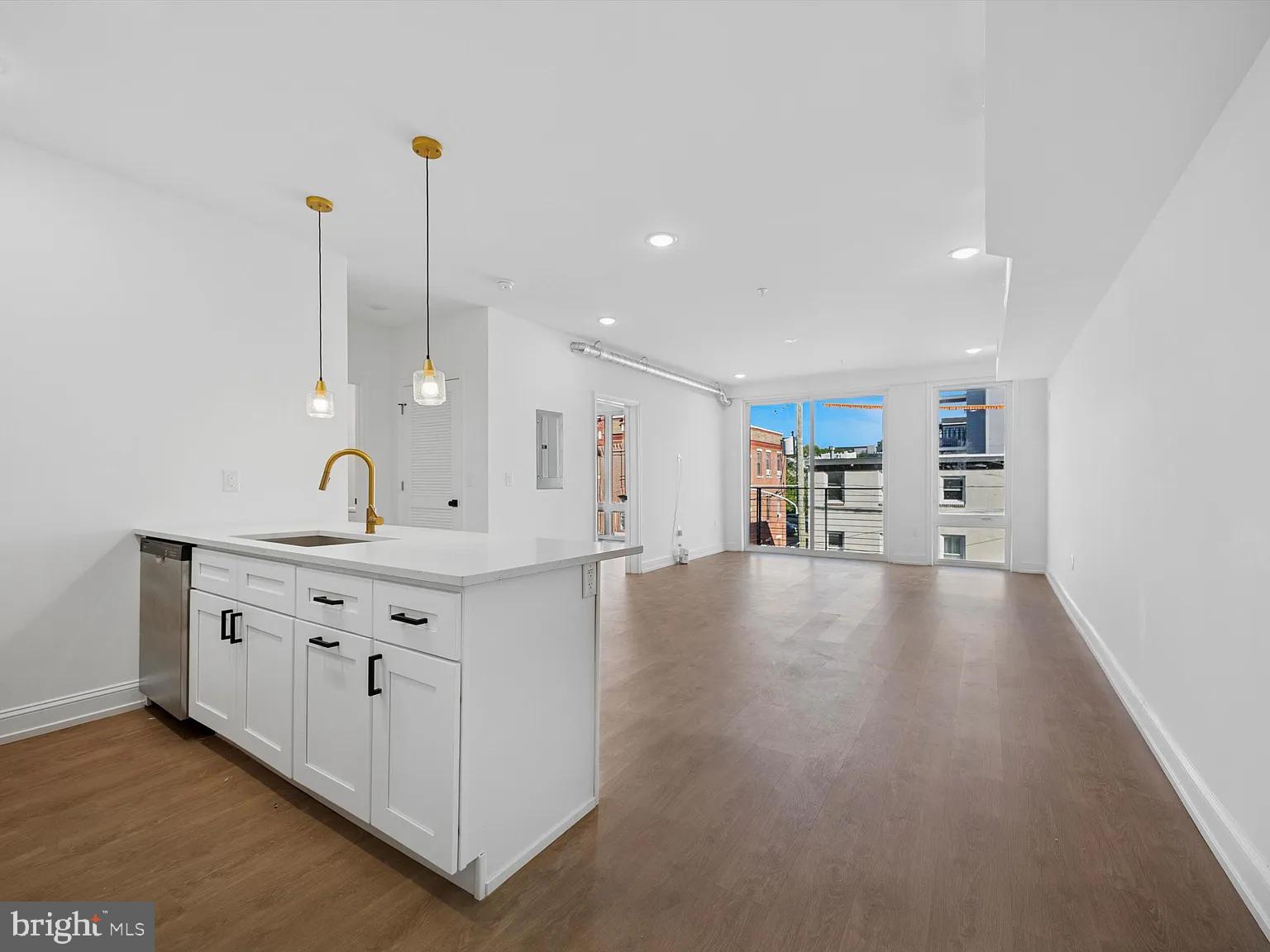 1614-20 Ridge Avenue, Unit 504 Philadelphia, PA 19130 - Photo 4 of 17 a view of a kitchen with kitchen island white cabinets and wooden floor