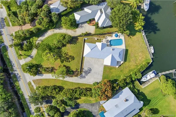 an aerial view of a house with a yard swimming pool and outdoor seating