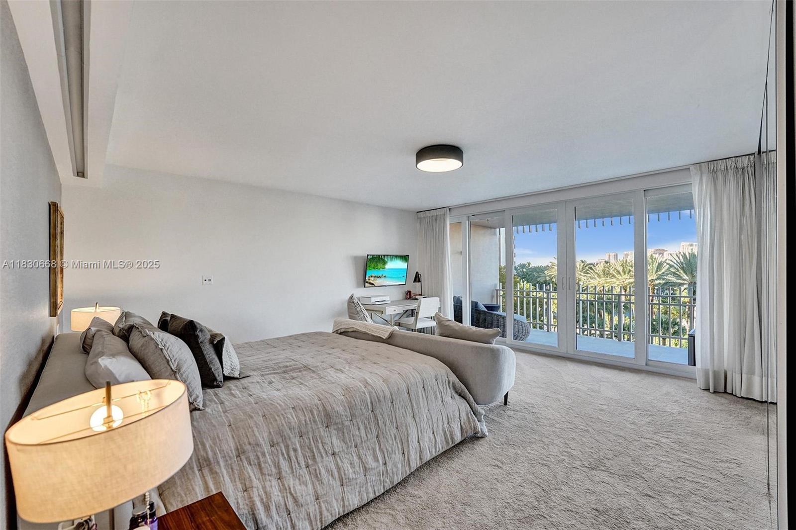 2 Grove Isle Drive, Unit B410 Miami, FL 33133 - Photo 29 of 43 a spacious bedroom with a bed and a large window