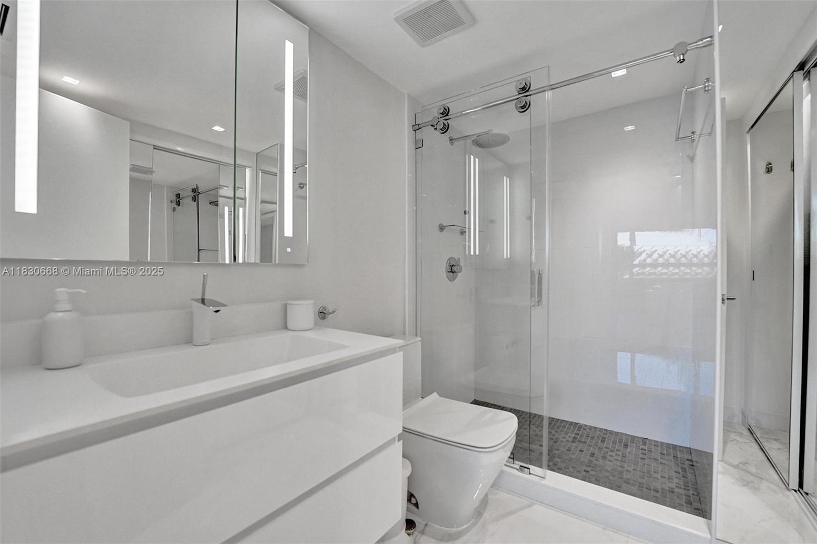 2 Grove Isle Drive, Unit B410 Miami, FL 33133 - Photo 31 of 43 a bathroom with a sink a toilet and shower