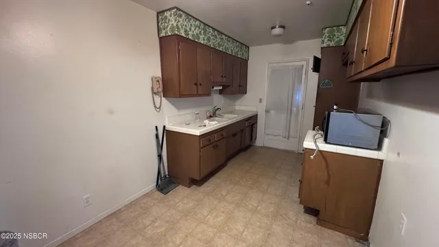 a kitchen with sink cabinets and stove top oven