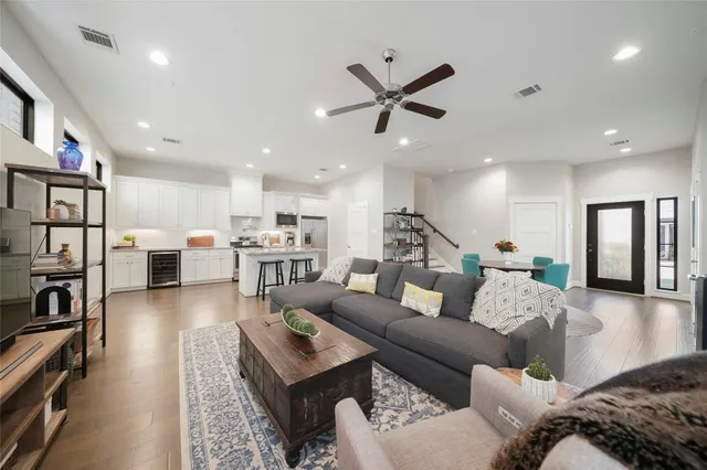 a living room with furniture a ceiling fan and a flat screen tv