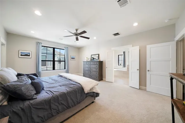 a spacious bedroom with a bed couch and a window