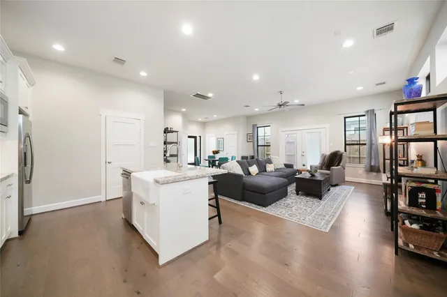 a living room with furniture wooden floor and a large window