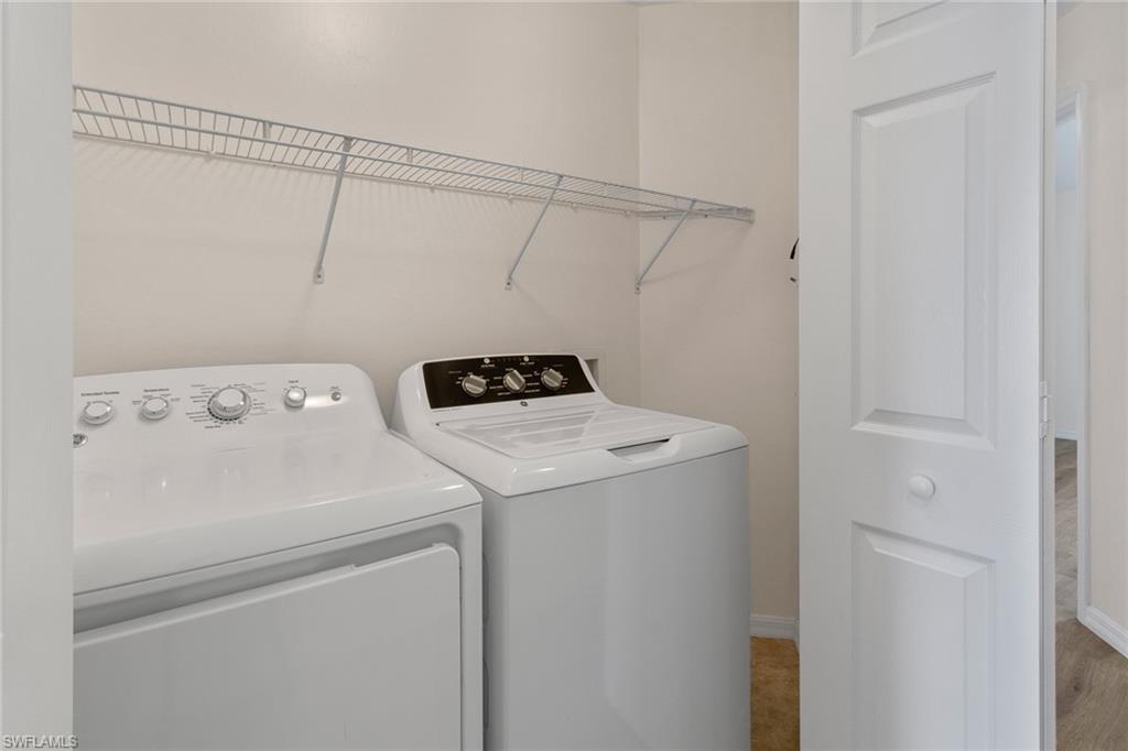 16235 Ravina Way Naples, FL 34110 - Photo 13 of 18 Dedicated laundry area featuring a wire shelving unit, a white paneled door, and neutral wall paint