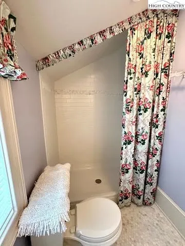 a bathroom with a toilet and shower curtain