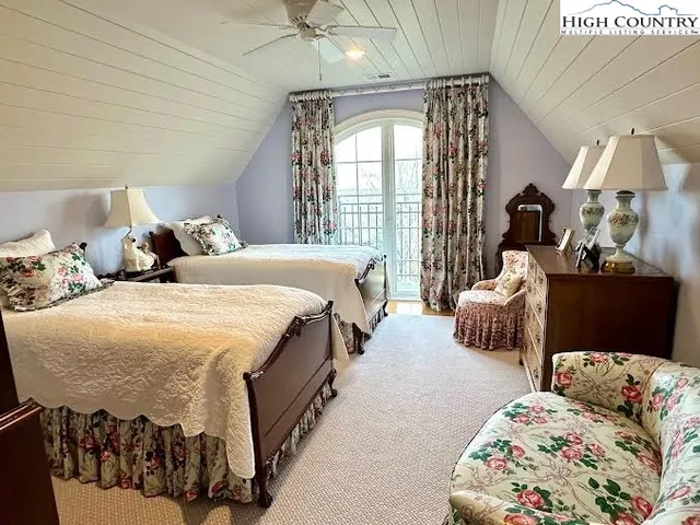 a spacious bedroom with two beds and a large mirror