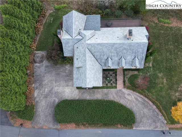 an aerial view of a house with a yard and trees