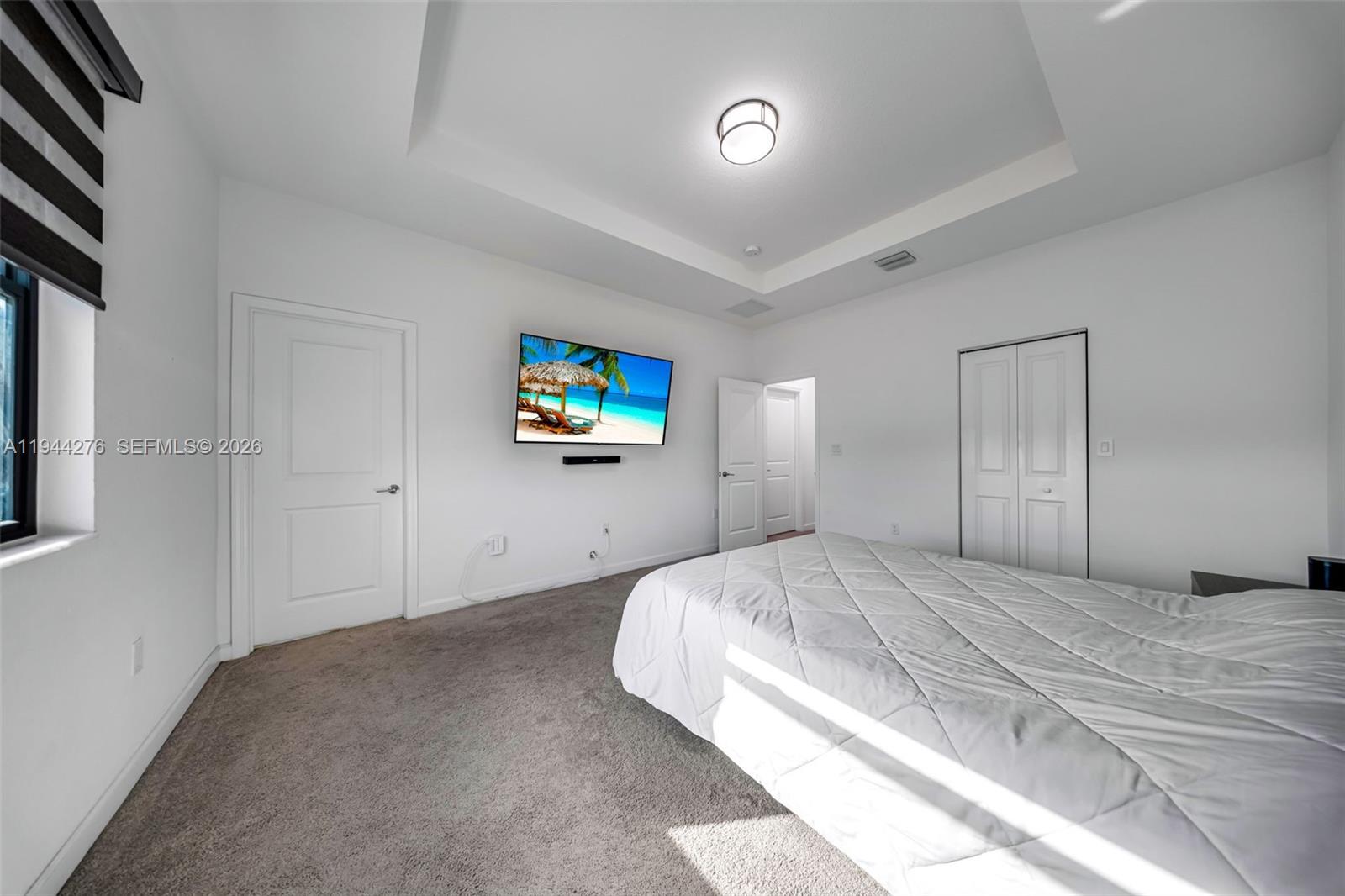 24985 Southwest 107th Court Homestead, FL 33032 - Photo 12 of 22 a bedroom with a bed and a chandelier