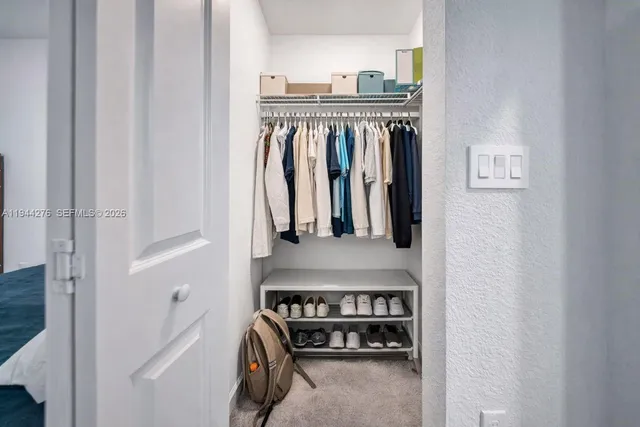 a view of walk in closet with clothes